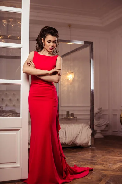 Юная леди в роскошном красном вечернем платье в интерьере — стоковое фото