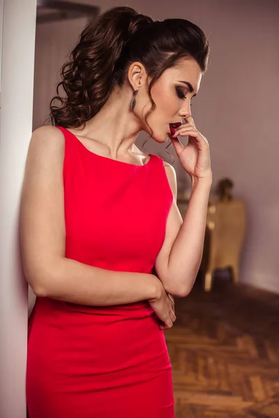 Jovem senhora em um lindo vestido de noite vermelho no interior — Fotografia de Stock
