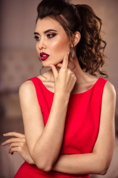 Young lady in a gorgeous red evening dress in interior — Stock Photo, Image