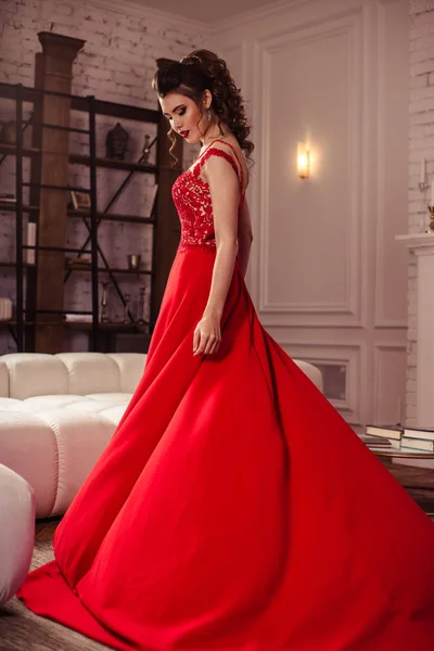 Jeune femme dans une magnifique robe de soirée rouge à l'intérieur — Photo