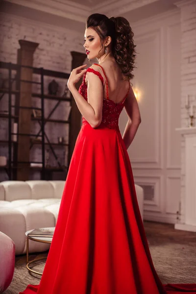 สาวน้อยในชุดราตรีสีแดงที่สวยงามในภายใน — ภาพถ่ายสต็อก
