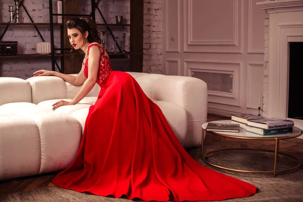 Jeune femme dans une magnifique robe de soirée rouge à l'intérieur — Photo