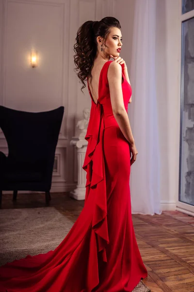 Jovem senhora em um lindo vestido de noite vermelho no interior — Fotografia de Stock