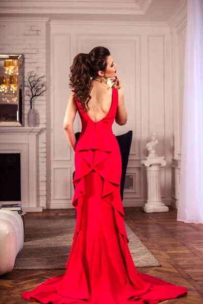 Νεαρή κοπέλα σε ένα πανέμορφο κόκκινο φόρεμα βράδυ στο εσωτερικό — Φωτογραφία Αρχείου