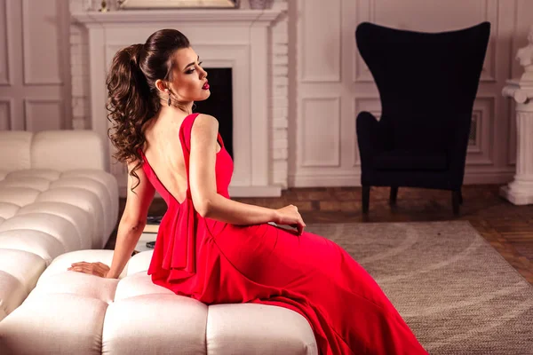 Jeune femme dans une magnifique robe de soirée rouge à l'intérieur — Photo