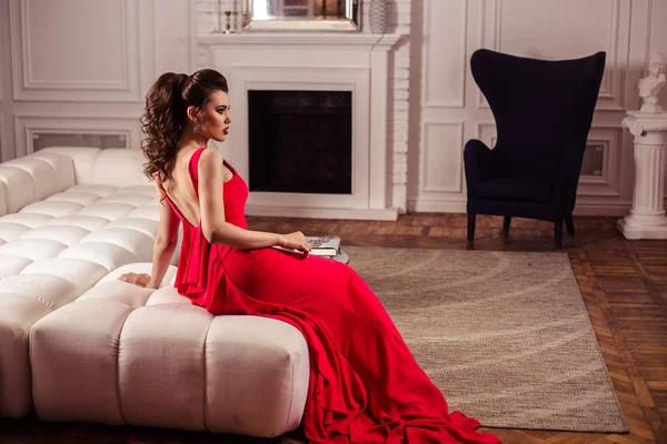 Jeune femme dans une magnifique robe de soirée rouge à l'intérieur — Photo