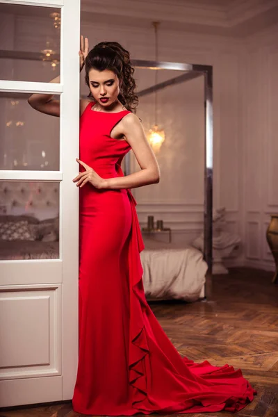 Jeune femme dans une magnifique robe de soirée rouge à l'intérieur — Photo