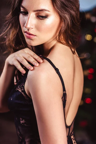 Portrait of sensual young woman in a black lingerie over christmas background — Stock Photo, Image