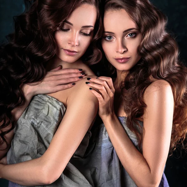 Hermosas gemelas mujeres jóvenes con maquillaje natural y estilo de pelo posando desnuda cubierta de tela gris, primer plano retrato —  Fotos de Stock