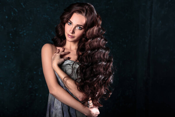 beautiful young woman with natural make-up and hair style posing naked covering with grey cloth