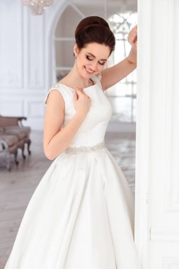 zarif saç ve makyaj uzun lüks gelinlik giyen güzel esmer gelin portresi