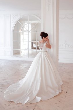 zarif saç ve makyaj uzun lüks gelinlik giyen güzel esmer gelin portresi