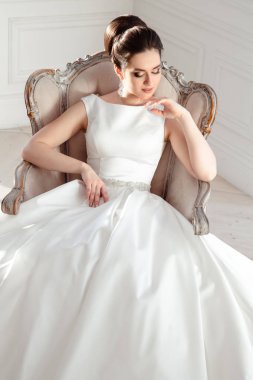 zarif saç ve makyaj uzun lüks gelinlik giyen güzel esmer gelin portresi