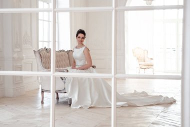 zarif saç ve makyaj uzun lüks gelinlik giyen güzel esmer gelin portresi