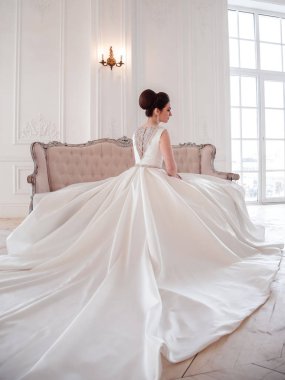 zarif saç ve makyaj uzun lüks gelinlik giyen güzel esmer gelin portresi