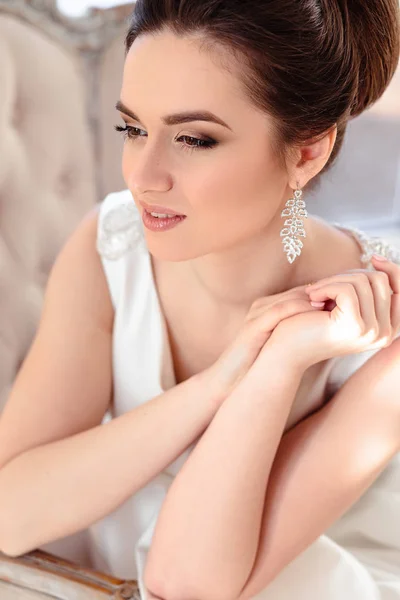 Närbild porträtt av vackra brunett brud med elegant frisyr och smink klädd i lång lyx bröllopsklänning — Stockfoto
