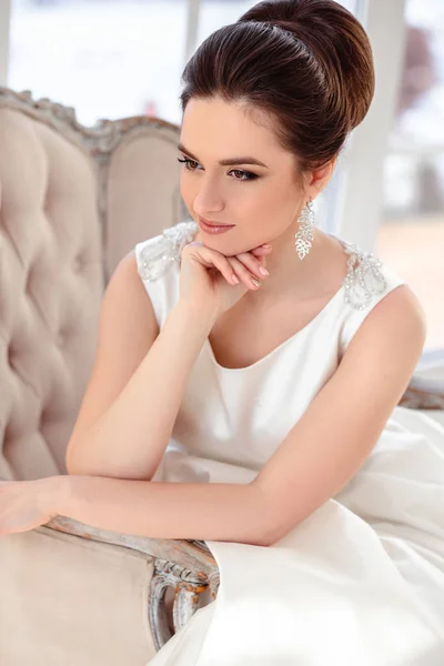 Close-up retrato de bela noiva morena com penteado elegante e maquiagem vestindo vestido de noiva de luxo longo — Fotografia de Stock