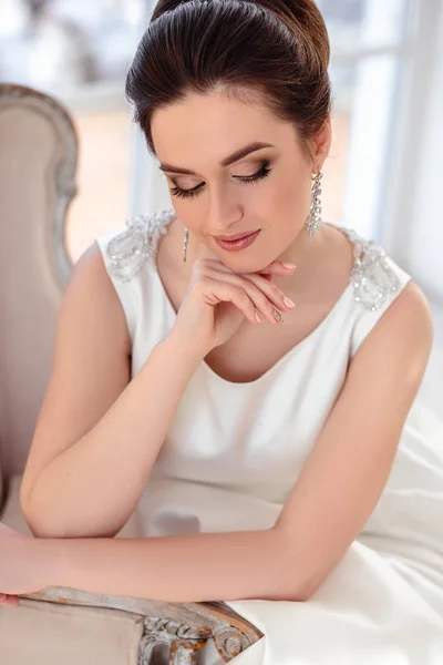 Close-up retrato de bela noiva morena com penteado elegante e maquiagem vestindo vestido de noiva de luxo longo — Fotografia de Stock
