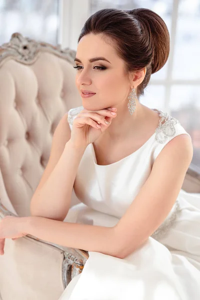Ritratto ravvicinato di bella sposa bruna con acconciatura elegante e trucco indossando lungo abito da sposa di lusso — Foto Stock