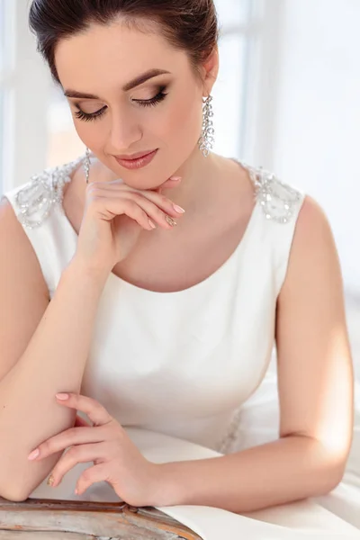 Ritratto ravvicinato di bella sposa bruna con acconciatura elegante e trucco indossando lungo abito da sposa di lusso — Foto Stock