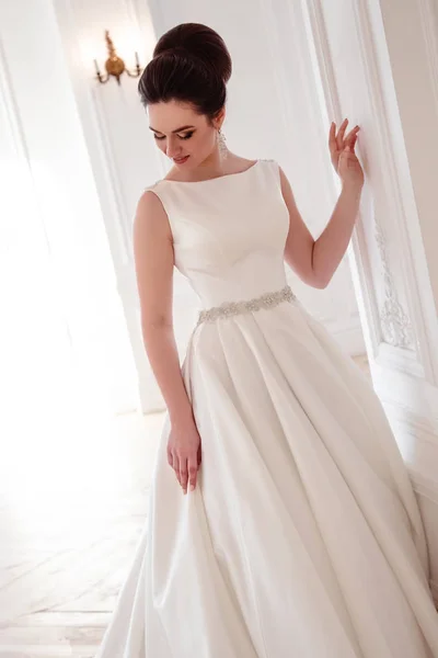 Portrait de belle mariée brune avec coiffure élégante et maquillage portant longue robe de mariée de luxe — Photo