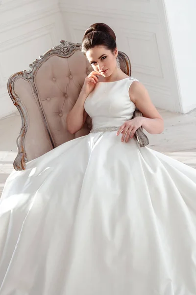 Retrato de hermosa novia morena con peinado elegante y maquillaje con vestido de novia de lujo largo — Foto de Stock