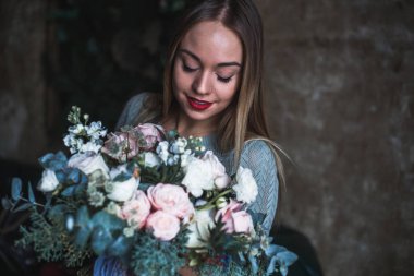 İş yerinde çiçekçi: genç ve güzel sarışın kadın moda modern buket farklı çiçek tutan