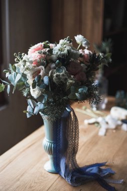 Çiçekçi işyeri: çiçek ve aksesuarları bir vintage ahşap masa üzerinde. yumuşak odak. Bir tabloda basit kompozisyon bir vazoda modern buket