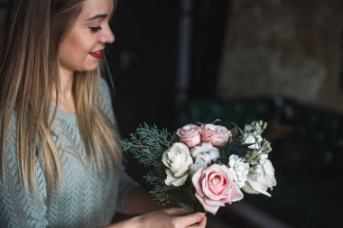 İş yerinde çiçekçi: genç ve güzel sarışın kadın moda modern buket farklı çiçek tutan