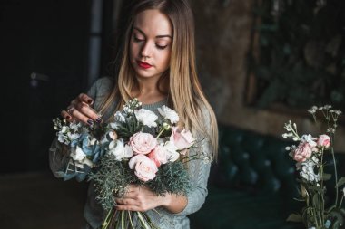 İş yerinde çiçekçi: genç ve güzel sarışın kadın moda modern buket farklı çiçek tutan