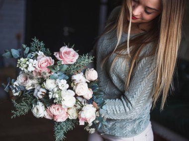 İş yerinde çiçekçi: genç ve güzel sarışın kadın moda modern buket farklı çiçek tutan