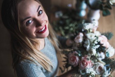 İş yerinde çiçekçi: genç ve güzel sarışın kadın moda modern buket farklı çiçek tutan