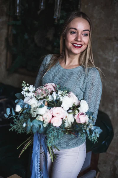 Florista en el trabajo: mujer rubia bastante joven sostiene ramo moderno de moda de diferentes flores — Foto de Stock