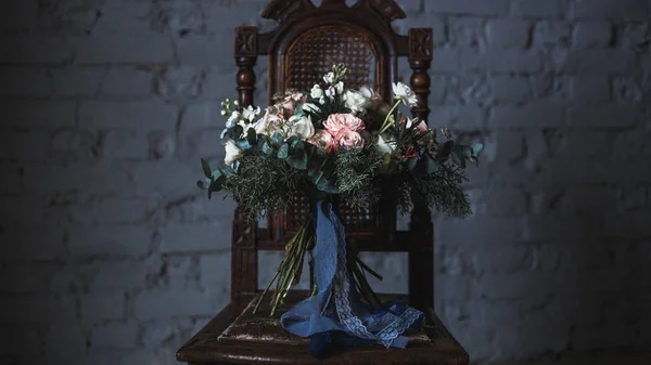 Florist workplace: flowers and accessories on a vintage wooden table. soft focus. Modern bouquet in a vase on a table, simple composition