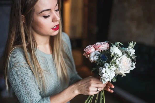 Florista en el trabajo: mujer rubia bastante joven sostiene ramo moderno de moda de diferentes flores — Foto de Stock