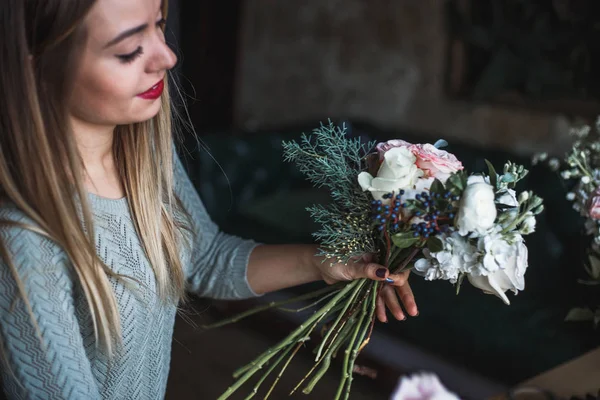 Florista en el trabajo: mujer rubia bastante joven sostiene ramo moderno de moda de diferentes flores — Foto de Stock