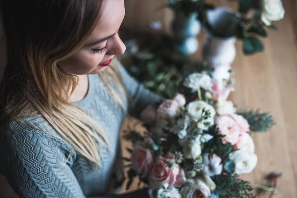 Florista en el trabajo: mujer rubia bastante joven sostiene ramo moderno de moda de diferentes flores — Foto de Stock