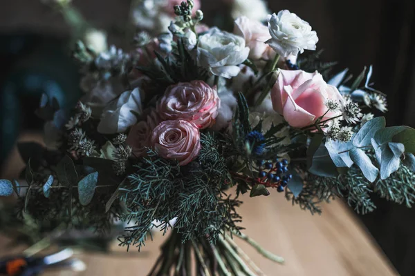 Floristik-Arbeitsplatz: Blumen und Accessoires auf einem Holztisch. Weichzeichner. modernes Bouquet in einer Vase auf einem Tisch, einfache Komposition — Stockfoto