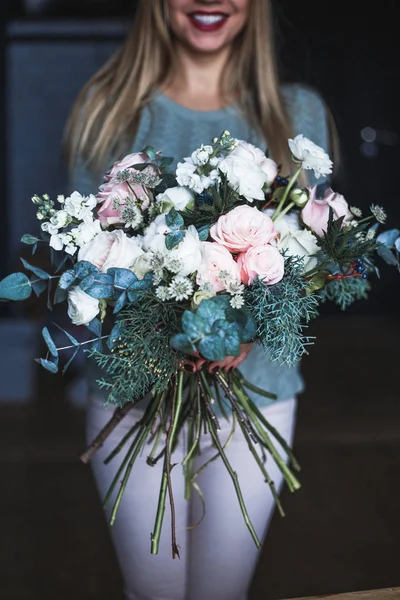 Kwiaciarnia w pracy: dość młoda blond kobieta trzyma moda nowoczesny bukiet kwiatów, różnych — Zdjęcie stockowe