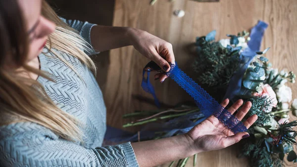 Florista en el trabajo: mujer rubia bastante joven sostiene ramo moderno de moda de diferentes flores — Foto de Stock