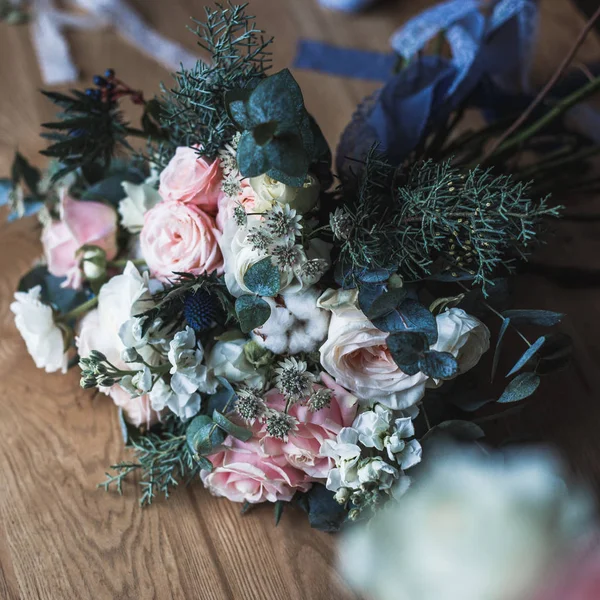 Local de trabalho florista: flores e acessórios em uma mesa de madeira vintage. Foco suave. Bouquet moderno em um vaso em uma mesa, composição simples — Fotografia de Stock