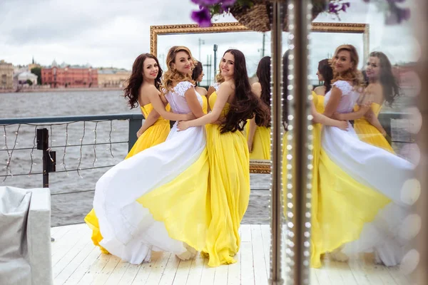 Mooie bruid en twee bruidsmeisjes in soortgelijke Tsechu samen op een zomer terras een zee-restaurant — Stockfoto