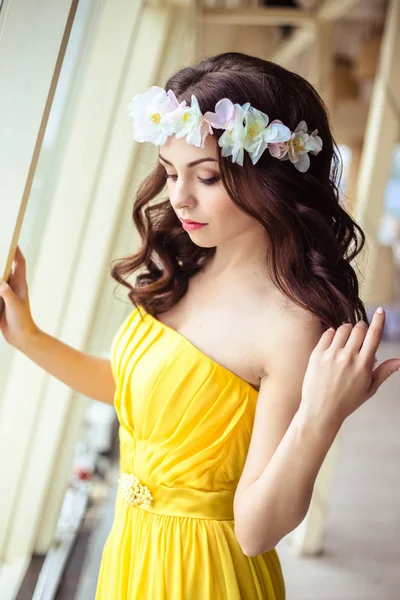 Hermosa joven con el pelo largo en un día de verano. dama de honor en vestido amarillo en un restaurante de mar — Foto de Stock