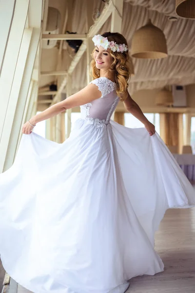Sexy junge blonde Braut in einem Kreuzfahrt-Hochzeitskleid in einem Sommer Meer Restaurant — Stockfoto