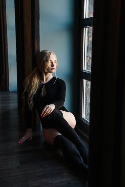 Kusursuz bir beden ile sarışın genç kadın bodysuits giyer.