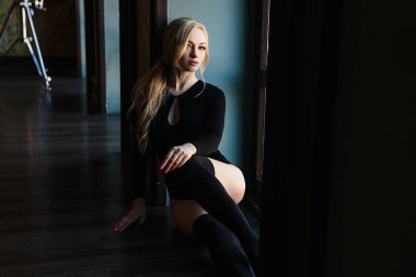 Kusursuz bir beden ile sarışın genç kadın bodysuits giyer.