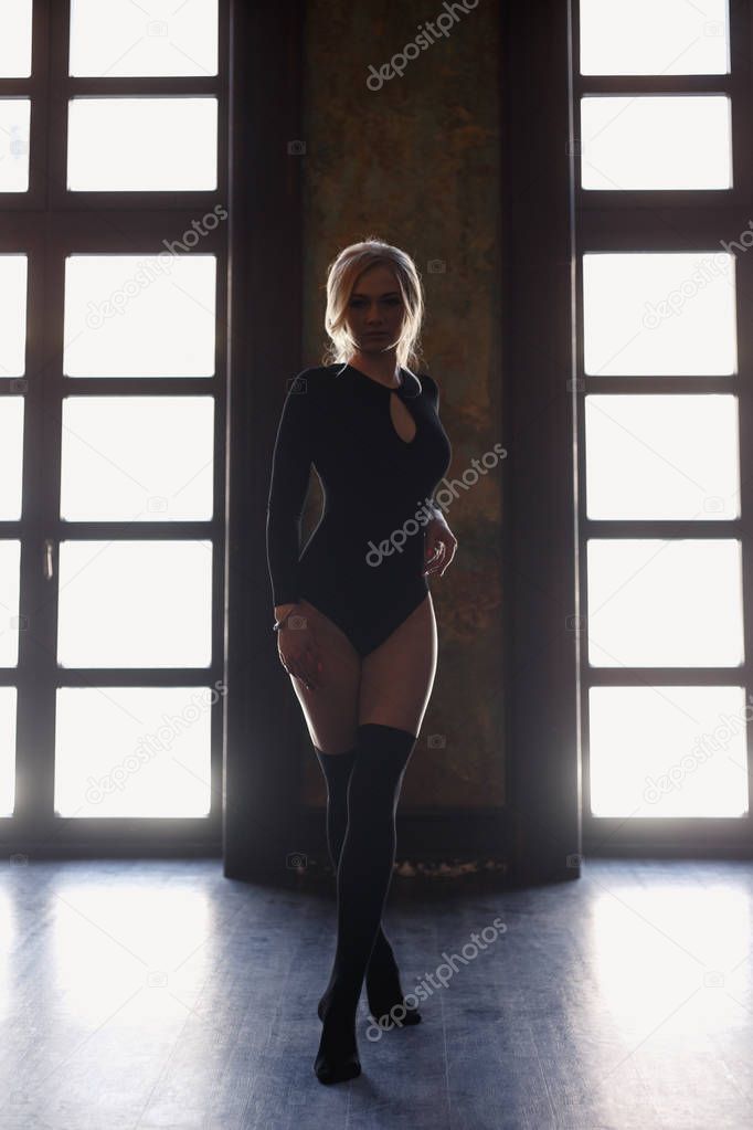 Young blonde woman with perfect body wears bodysuits.