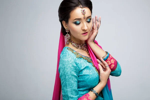 Portrait of beautiful smiling indian girl. Young indian woman model with traditional jewelry set . Indian costume saree