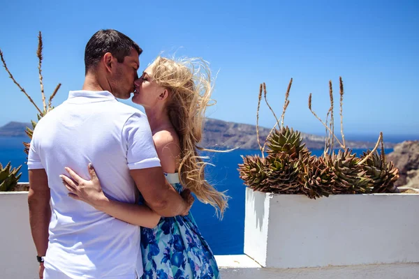 Beautiful young woman and man in their summer vacation walk on greek island Santorini — Stock Photo, Image