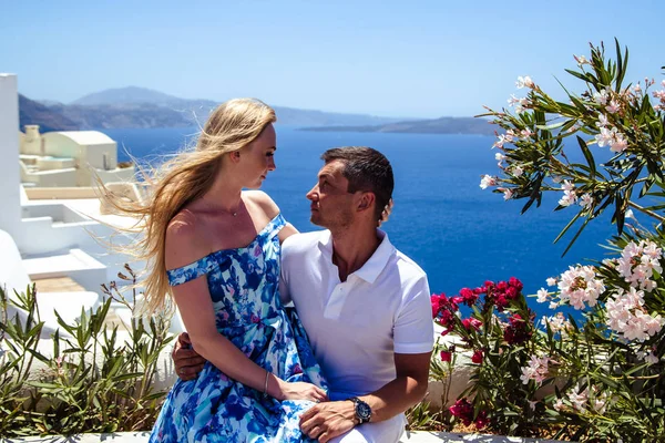 Beautiful young woman and man in their summer vacation walk on greek island Santorini — Stock Photo, Image